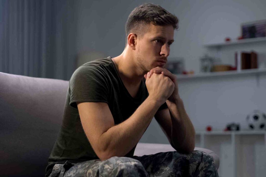 Man sitting alone feeling anxious and overwhelmed representing PTSD and trauma symptoms
