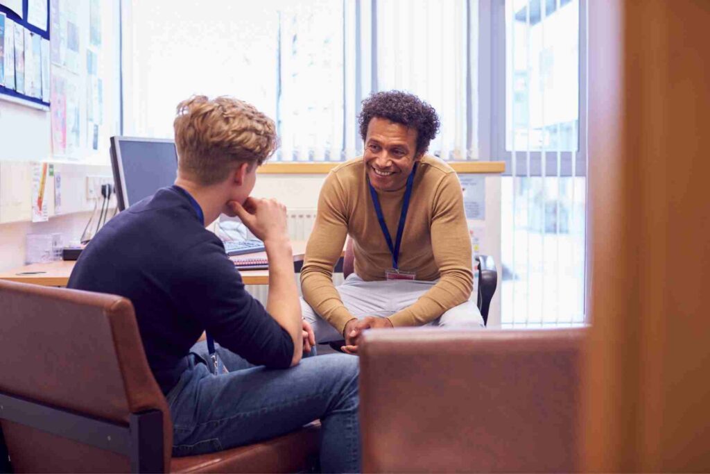Mental health counselor speaking with a young adult during a first therapy session in a private counseling office.