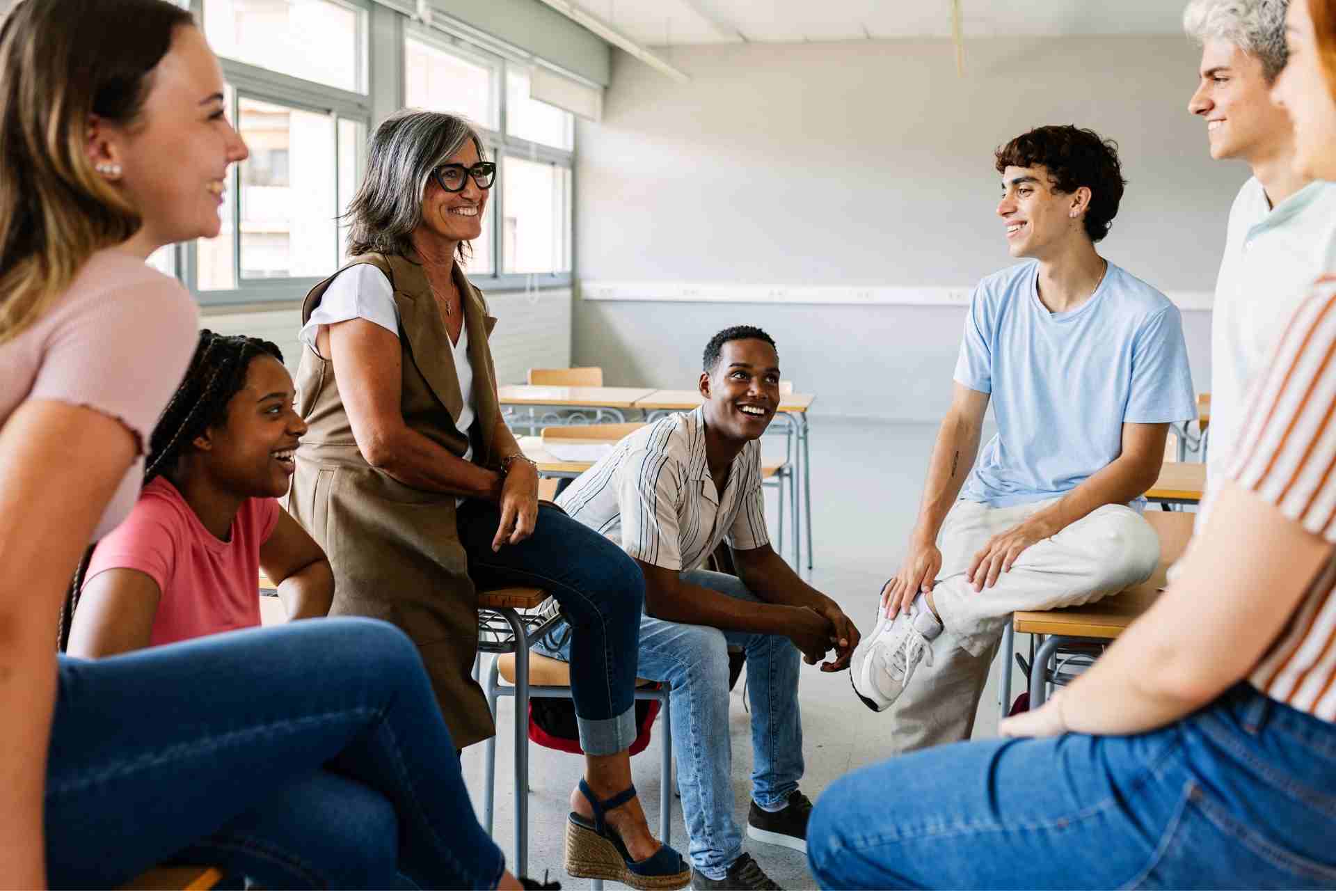 A licensed therapist leads a supportive group therapy session with adults discussing mental health and emotional wellness.