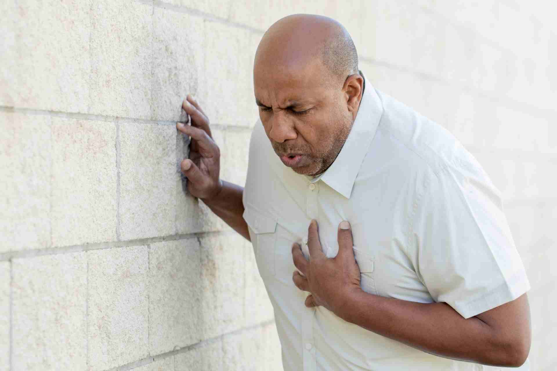 Man clutching his chest while experiencing severe chest pain requiring immediate medical evaluation