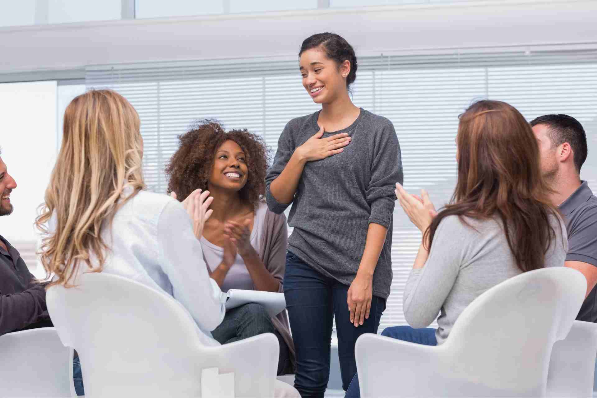 Participant sharing progress during a supportive group therapy session in a mental health treatment program