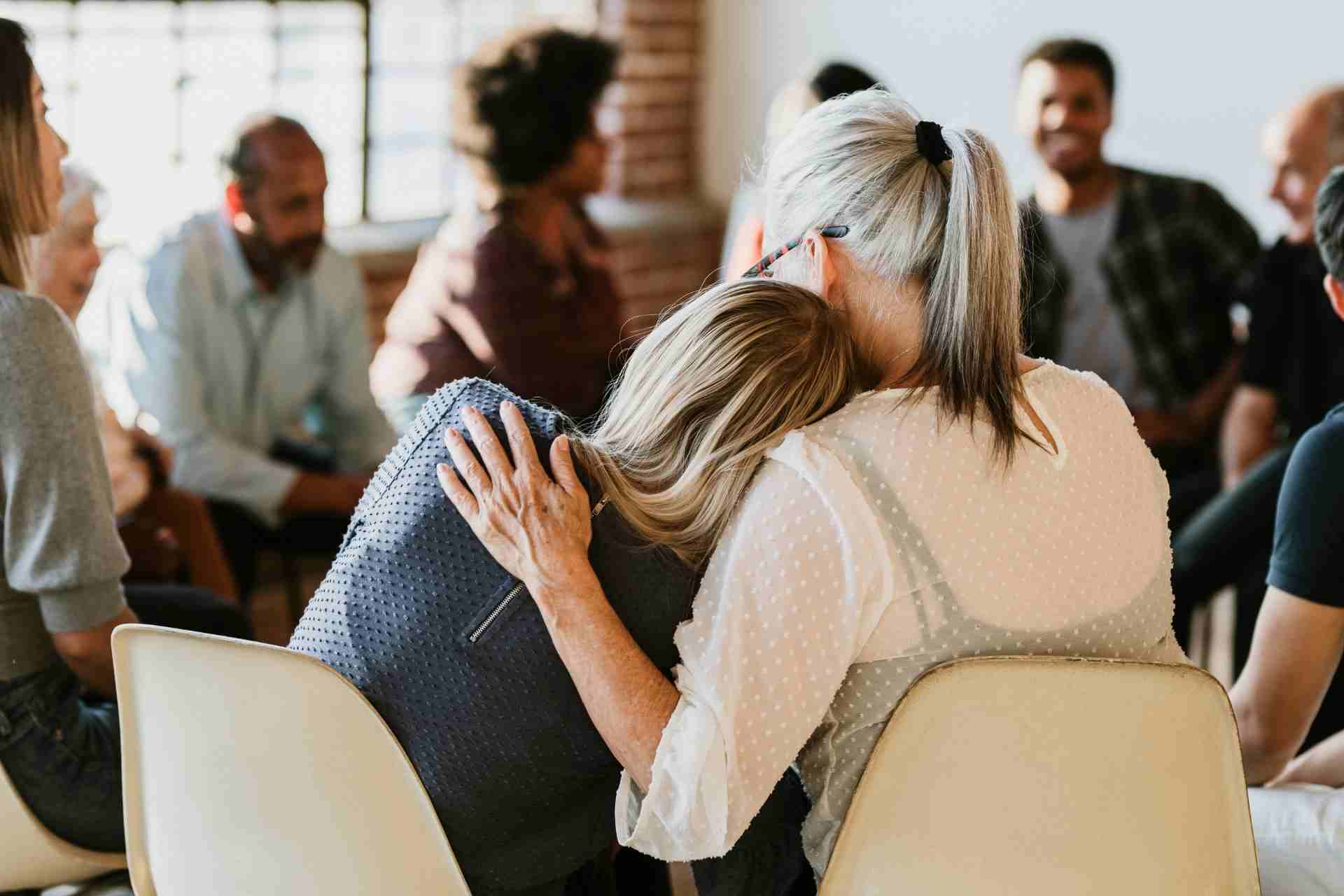 Professional receiving emotional support during a confidential mental health group therapy session
