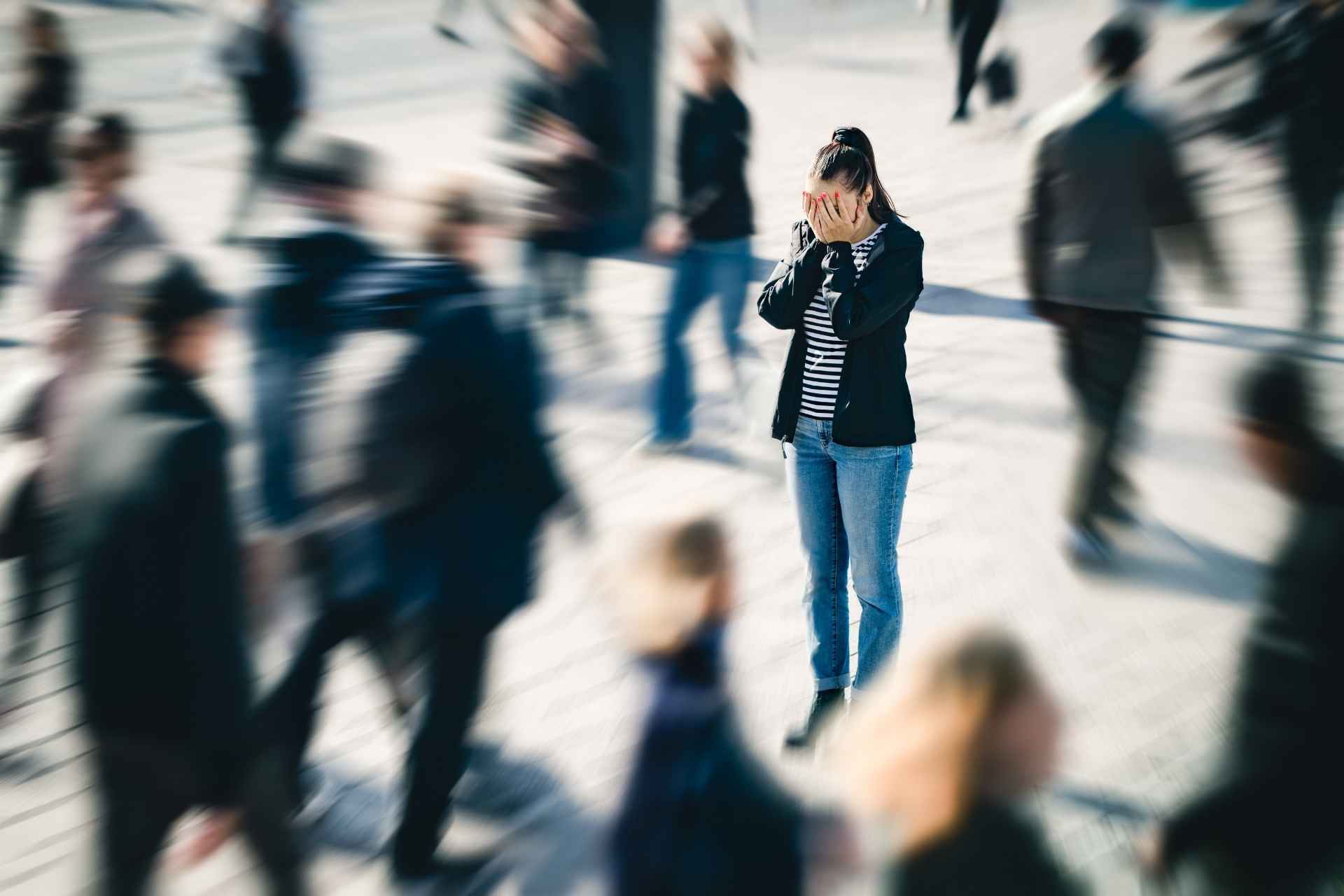 Woman overwhelmed by social anxiety in a crowded public place